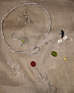 Kinder und Jugendliche fertigen römische Kettenanhänger, Ringe und Armreifen aus Draht und Perlen an.