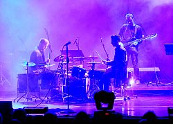 Magic Drums der Städtischen Musikschule: 

Zwei Musikschüler sitzen sich an kombinierten Schlagzeugen in der Stadthalle gegenüber und spielen. Im Hintergrund steht ein Gitarrist (E-Bass). Das Licht ist in lila gehalten. 