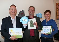Bei der Pressekonferenz zur Vorstellung der neuen deutsch-spanischen Umweltbildungsmaterialien zeigen Manfred Kaiser, Tilman Petters und Antje Kirsch Buch, Anschauungskarten und Handpuppen in die Kamera