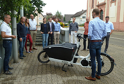 Martin Stehr steht an einem E-Lastenrad, rundum Vertreter der Gemeinden des Mobilitätswerks Ortenau. 