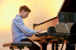 Ein junger Pianist sitzt am Flügel