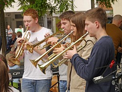 Ein Trompetenquartett von drei Jungs und einem Mädchen spielen während dem Musikschultag.