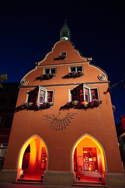 Das Alte Rathaus in Lahr, am Abend, mit roten Scheinwerfern angestrahlt.