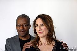 Porträtbild eines schwarzen Mannes im Hintergrund und einer weißen Frau im Vordergrund.