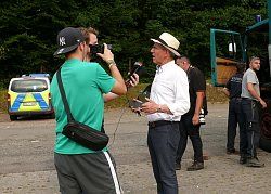 OB gibt Interview, im Hintergrund ein Polizeiwagen und der LKW des Kampfmittelbeseitungsdienst. 