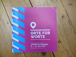 Das Programmheft der Lahrer Literaturtage Orte für Worte 2017 fotografiert auf Holzdielen.