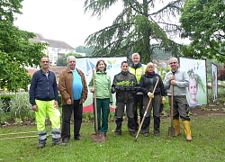 von links nach rechts  haben sich Thierry Paillet (Grünflächen Stadt Dole), Stadtrat Jean-Pierre Cuinet , Christina Volz, Jakob Maus, Markus Neugebauer, Hildegard Haas und Gery Deletoille haben sich in der Grünanlage in Dole zum Gruppenbild positioniert. Im Hintergrund sieht man die Kunstwerke mit den Blumentöpfen. Die Gärtner selbst haben Spaten in der Hand. 