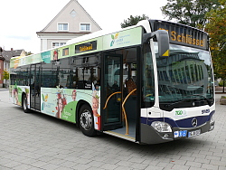 Das Bild zeigt einen Bus der SWEG auf dem Lahrer Rathausplatz. Auf dem Bus wurde großflächig Werbung für die Landesgartenschau angebracht.