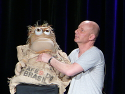 Benjamin Tomkins mit einer Puppe, die aussieht wie ein sprechender Sack