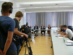 Zu sehen ist der kleine Sitzungssaal im Rathaus 2 in Lahr. Am Tisch vorn sitzen Oberbürgermeister Dr. Wolfgang G. Müller, der leiter des OB-Büros, Arnfried Sickinger und die Ptressesprecherin Ulrike Karl. Links und rechts an Tischen sitzen mehrere Journalisten, im Vordergrund Kameraleute bei der Arbeit.