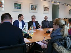 Auf dem Bild ist das Sitzungszimmer im Rathaus 1 in Lahr zu sehen. An einem großen Holztisch sitzen Medienvertreter, ihnen gegenüber sitzen Oberbürgermeister Dr. Müller, Markus Ibert und Arnfried Sickinger.