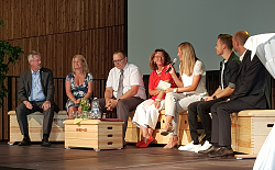 Podium bei der Einweihung der neuen Sporthalle
Mehrere Personen sitzen auf Sportpodien und diskutieren miteinander. 