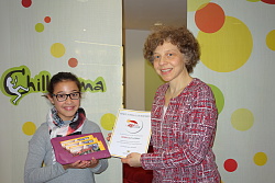 Joline-Lara Allgaier steht neben Karin Schmidt vor einer weißen Wand mit der Aufschrift Chill-Arena. Joline-Lara hält die drei Eintrittskarten und Frau Schmidt eine Urkunde lächelnd in die Kamera. 