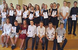 Die Preisträger gruppieren sich gemeinsam mit Erster Bürgermeister Guido Schöneboom zu einem Gruppenbild und halten lächelnd ihre Medaillen und Urkunden in die Kamera. 