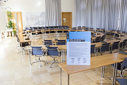 Das 2012 vom Gemeinderat beschlossene energie- und klimapolitische Leitbild ist die Grundlage für Lahrs ehrgeizige Klimaschutzmaßnahmen. Die Erklärung steht in einem durchsitigen Schild auf einem Tisch im Gemeinderatssaal. Im Hitnergrund sind die zu einem Halbkreis gebildeten Tische mit Stühlen zu sehen.