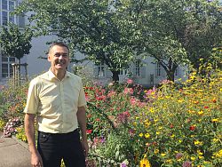 Ralph Brucker, Leiter der Abt. Liegenschaften und Verwaltungsservice bei der Stadt Lahr im Rathausinnenhof vor einem bunten Blumenbeet.