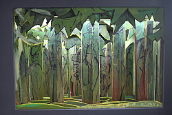 Die Rauwmunderbox ist schwarz bemalt. Darin eröffnet sich eine Welt, die an einen Wald erinnert. Die Baumstämme sind mit erdfarbenen Tönen bemalt, es scheint indirektes Licht ziwschen den Bäumen.