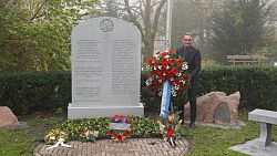 Oberbürgermeister Markus Ibert steht mit einem Blumenkranz am Ehrenmal der kanadischen Soldaten auf dem Bergfriedhof in Lahr.