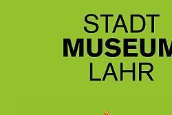 Zu sehen ist ein Apfel mit einer Zielscheibe als Aufkleber, der an die Obstaufkleber Aufkleber im Supermarkt erinnert. Es ist ein Plakat zur Ausstellung &#34;500 Jahre Schützen&#34; des Stadtmuseums Lahr. Der Zeitraum ist von 06. Mai bis 20. September 2026.