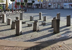 In einem Kreis mehrere ringförmig angeordnete Steinstelen auf dem Marktplatz