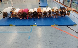 Kinder beugen sich über eine Bank. 