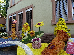 Zu sehen ist der Ausschnitt eines Wagens. Als Motiv ist ein Wurm und eine Trommel zu sehen, die mit bunten Chrysanthemen beklebt sind. 