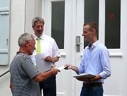 Zu sehen sind Bürgermeister Tilman Petters und Martin Stehr  vom Stadtplanungsamt bei der Übergabe einer Siegerurkunde des Stadtradelns 2018 an eine Teilnehmenden.