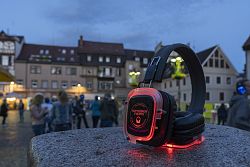 Rot leuchtender Kopfhörer auf einem Stehtisch, im Hintergrund der abendliche Lahrer Marktplatz
