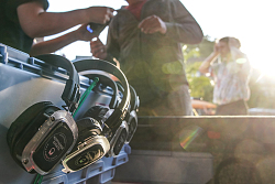 Auf dem Foto sind mehrere Kopfhörer an einer Kiste befestigt, die auf ihre Ausgabe an die Gäste warten 