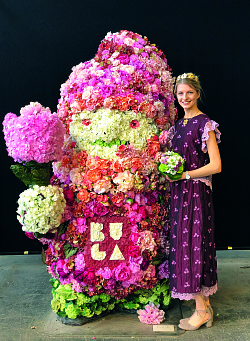 Die Chrysanthemenkönigin der Stadt Lahr, Sonja I., im neuen Kleid neben dem blumigen Maskottchen der BuGa 