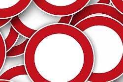 Zu sehen sind mehrere neben- und übereinander liegende Sperrschilder (weißer Kreis mit rotem Rand).