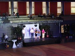 Ehrung der Ehrenamtlichen des Sports. Sie stehen auf der Tribüne und halten ihre Ehrung und Blumensträuße in der Hand. 