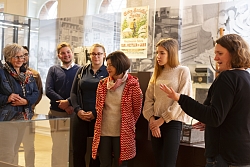 Das Foto zeigt mehrere Personen. Eine Person erläutert etwas und die anderen hören interessiert zu.