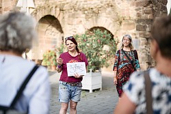 Katrin Bucherer und Uta Lingner stehen mit einer Menschengruppe vor dem Storchenturm und erzählen von der Geschichte, der Architektur und mehr.