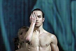 Ein Mann im Porträt vor dunklem Hintergrund.