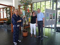 Zu sehen sind Kikuto Sakagawa, Martina Mundinger und Reinhard Krämer im Bürgerbüro Lahr. Sie stehen neben einem Bäumchen, das mit Wunschkärtchen zum japanischen Tanabata-Fest verziert ist.