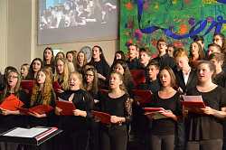 Zu sehen sind Schüler des Clara-Schumann-gymnasiums bei der Chorprobe. Sie stehen aufgereiht hintereinander und tragen schwarz.