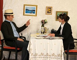 Dr. Hubert Schreiner und seine Tochter sitzen am Tisch und unterhalten sich. 