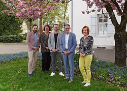 Die Geschäftsführer der Tourismusagentur Pilum David Osebik und Johannes Terler (Erster und Dritter von links) mit Friederike Ohnemus, Leiterin Abteilung Ratsarbeit, Marketing und Internationales, Oberbürgermeister Markus Ibert und Martina Mundinger, Leiterin Stadtmarketing (von links) stehen im blühenden Rathausinnenhof. 