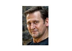 Ein Mann mit braunen Haaren ist im Portrait abgelichtet.