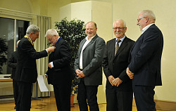 Stadt Lahr: Verleihung der Verdienstmedaille im Haus zum Pflug. Oberbürgermeister Dr. Wolfgang G. Müller mit Amtskette überreicht die Verdienstmedaille an Günter Endres, die anderen Geehrten stehen daneben. Alle sind dunkel gekleidet. 