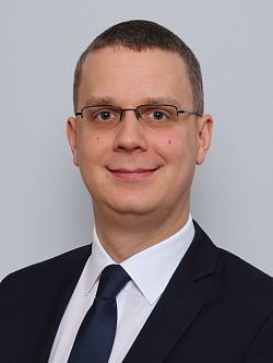 Michael Voigt, der neue Wirtschaftsförderer der Stadt Lahr, ist im Porträt abgebildet. Er hat sehr kurze braune Haare, trägt eine dezente Brille und lächelt in die Kamera. Er hat einen blauen Anzug mit blauer Kravatte auf weißen Hemd an. 