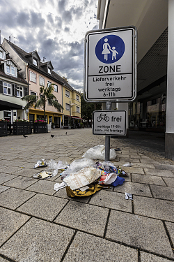 Verpackungen liegen auf dem Boden neben einem Mülleimer in der Lahrer Innenstadt.