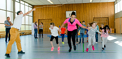 Zur Auftaktveranstaltung von fit4future an der Grundschule Sulz rennt die Hochspringerin mit Kindern lachend unter einem schwingenden Seil durch. 
