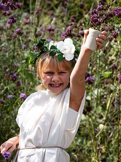 Das Foto zeigt eine junge Gallo-Römerin in ihrem Gewand und mit Blumenschmuck im Haar