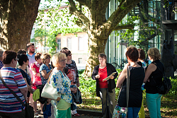 Das Bild zeigt Stadtführerin Doris Kronawitter im Rathauspark inmitten einer Gruppe Frauen.