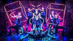 Artistinnen und Artisten in leuchtenden Anzügen