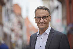 Portrait von Markus Ibert, im Hintergrund verschwommen die Marktstraße