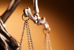 Symbolbild der Justitia mit Teilausschnitt mit Blick auf die Waage
