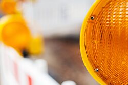 Sperrung einer Baustelle mit gelben Warnlicht im Vordergrund